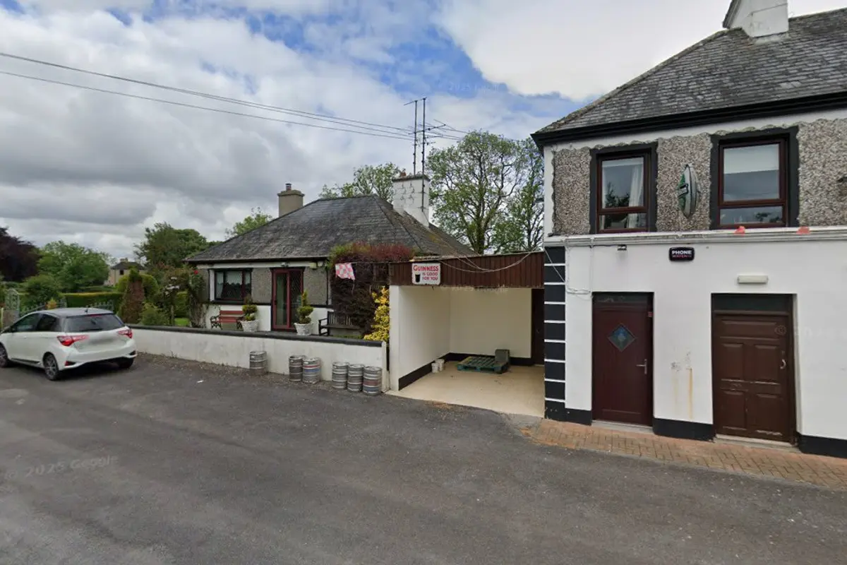 Side view of Donegan's Pub with Guinness sign and beer kegs